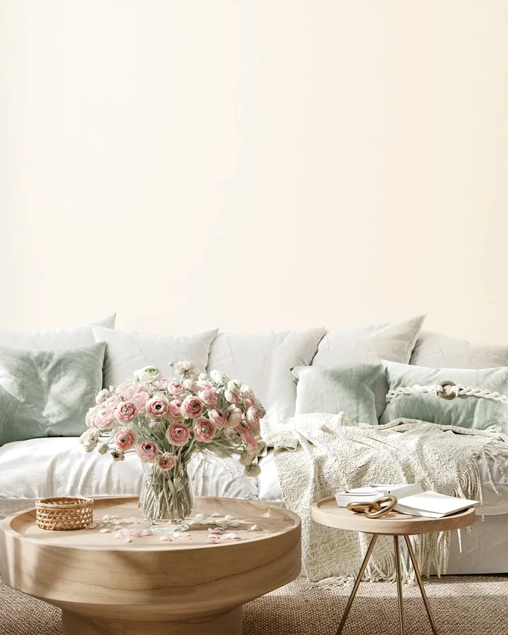 A living room filled with furniture and vase of flowers on a table