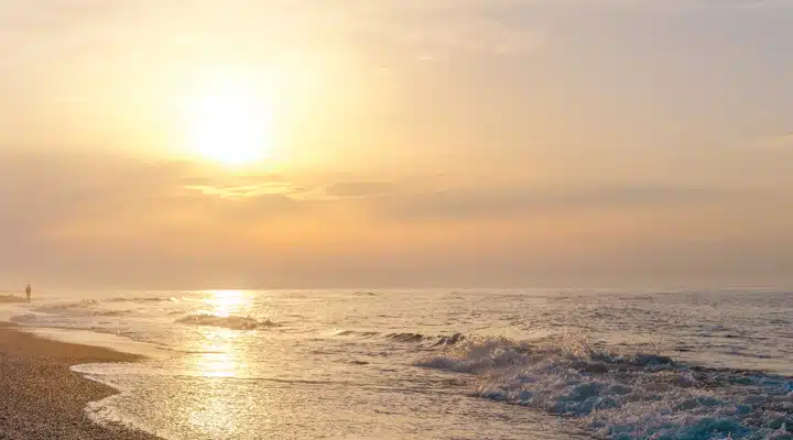 A sunset over a beach next to the ocean