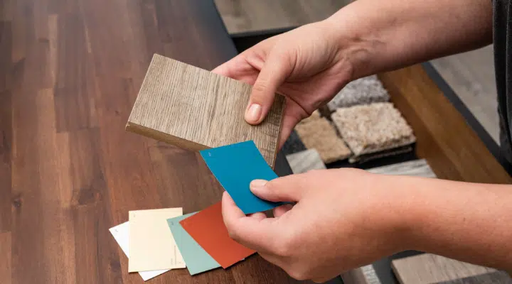 A hand holding a wooden cutting board