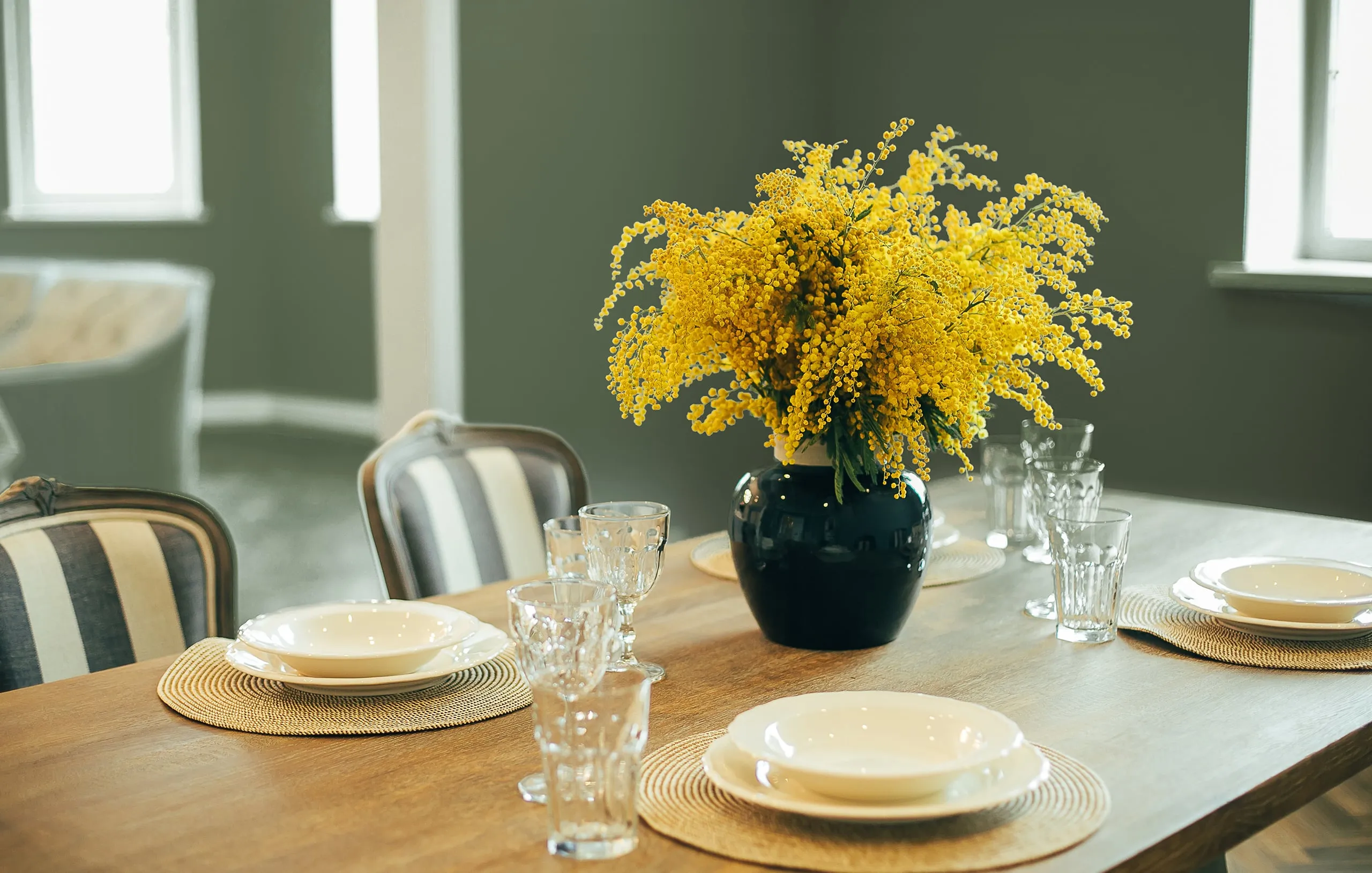 A cup of coffee and a vase of flowers on a table